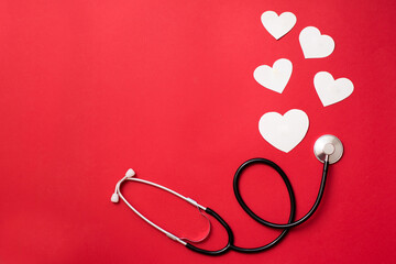 hearts and stethoscope , heart health care concept, red background with copy space