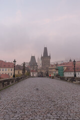 Obraz premium Landscapes on Charles Bridge with Bridge Tower and Statues at sunrise in a foggy morning, Prague, Czech Republic, Europe