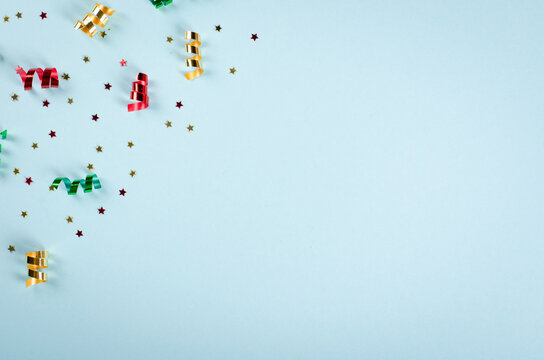Colored confetti and air balloons composition on blue background, party and celebration decoration.