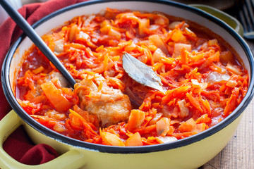 Pollock in a tomato marinade with onions and carrots in a round shape, selective focus