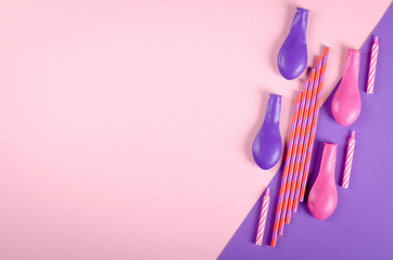 Colored candles and air balloons composition on purple background, party and celebration decoration.