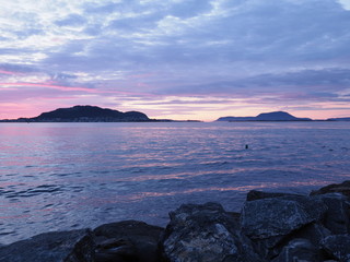 Rocks on landscape of bay seen from european Alesund town at Romsdal in Norway at blue hour