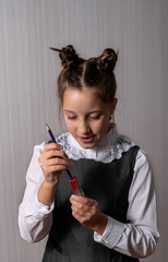 girl in a gray dress with a sharpener for the pencil