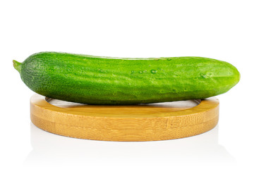 One whole fresh green baby cucumber on bamboo coaster isolated on white background
