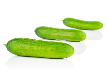 Group of three whole fresh green baby cucumber placed diagonally isolated on white background