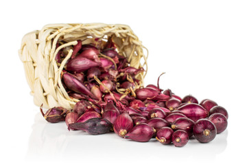 Lot of whole small red onion bulb in bast basket isolated on white background