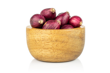 Obraz premium Lot of whole small red onion bulb in tiny wooden bowl isolated on white background