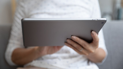 Closeup view female hands holding digital electronic device tablet computer