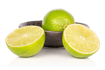 Group of one whole two halves of sour green lime in glazed bowl isolated on white background