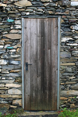 Porta di legno rustica con muro in pietra