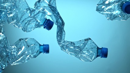 Super Slow Motion Shot of Flying Empty Plastic Bottles on Blue Gradient Background at 1000fps. Filmed with High Speed Cinema Camera at 4K. - Powered by Adobe