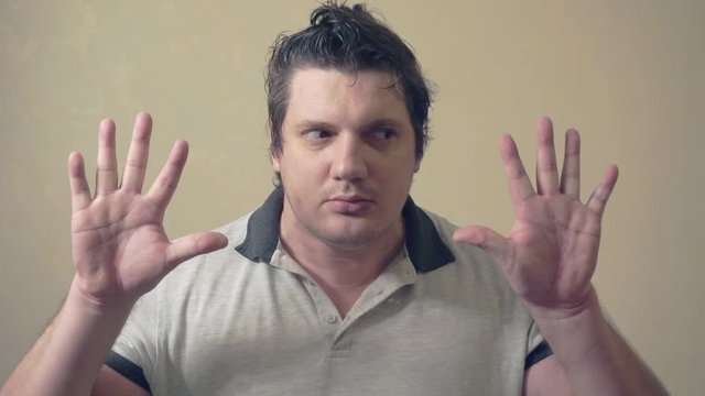 funny emotional man shows various grimaces resting against an invisible wall.cheerful middle aged male.video portrait
