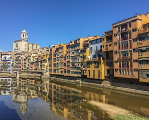 Buildings in residential district in Girona on bank of Onyar river with cathedral view 