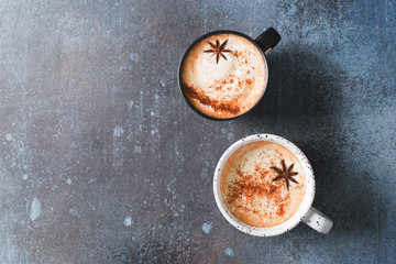 Obraz na płótnie Canvas Two cups of coffee with crema, cinnamon and badian on dark background