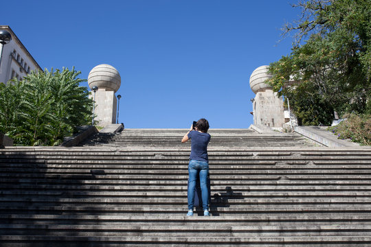 Young tourist woman taking pictures from Coimbra Monumental Stairs