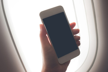 Woman hand using smart phone on airplane