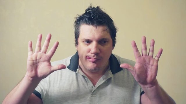 funny emotional man shows various grimaces resting against an invisible wall.cheerful middle aged male.video portrait