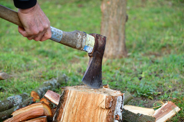 Detail on an ax as it cuts logs of wood into smaller pieces