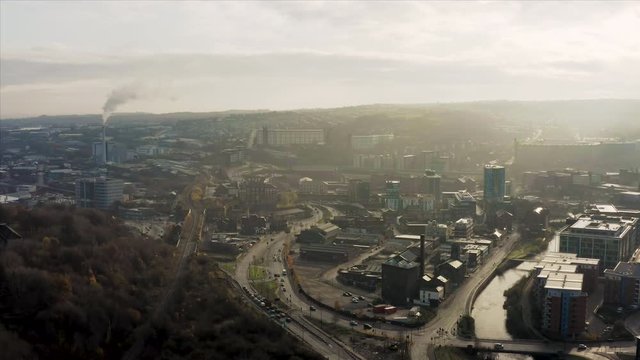 Aerial fly over Sheffield City during a winter sunrise showing the River Don and the skyscrapers in the developing city