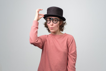 Funny mature caucasian in black hat woman saying hello or welcome greeting her friends. Studio shot