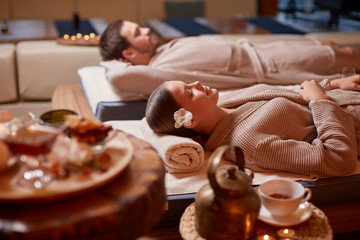 Drinking tea and relaxing in spa salon, lying down on beds and enjoy wearing bathrobe