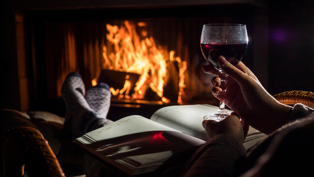 Sitting by the fireplace with a blank notebook and a glass of wine - planning a new life concept