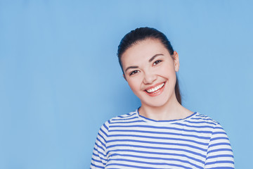 Smiling woman mouth with white healthy teeth on blue background.