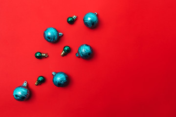 Red background with christmas balls in the corner, space for text, flat lay.