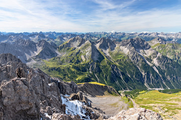 Fototapeta na wymiar Wild alpine landscape with rocky mountains, green grass and blue sky in the Lechtal Alps, Tirol, Austria