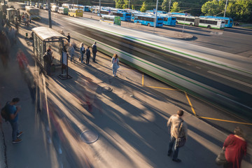 passengers in the queue for boarding the bus on a busy street at the end of the day
