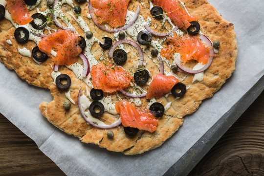 Flat bread with smoked trout, olives and onions