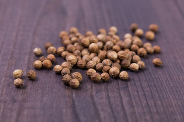 Seeds of coriander on a wooden background. Dry cilantro. Angle view