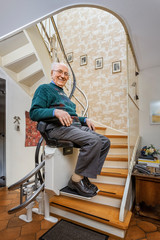 Elderly Man in the Staircase Using the Stairlift