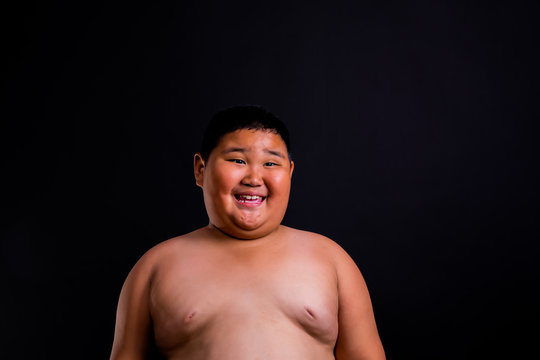 Fat chubby boy show cute, cheerful, happy, standing, hands clasped, smiling, close-up. Black background