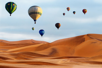 Beautiful Colorful Hot Air Balloons and dramatic clouds over the sand dunes in the Namib desert