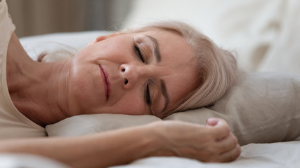 Close up view sleeping middle-aged woman lying on pillow