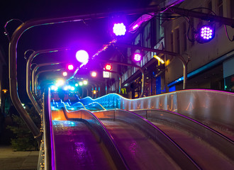 Ice slide illuminated at night with colorful lights