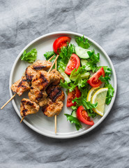 Pork skewers and vegetables fresh salad on a grey background, top view. Delicious healthy diet food