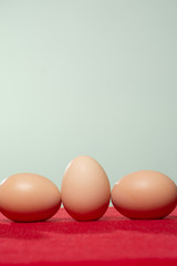 Whole eggs with set in a row on red background.