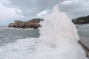 dangerous waves hiting a breakwater 