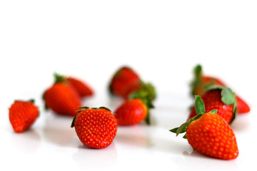 Bright red fresh ripe strawberries berries scattered and isolated on a white background