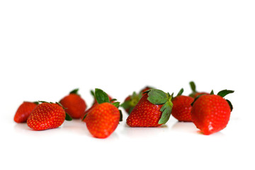 Bright red fresh ripe strawberries berries scattered and isolated on a white background