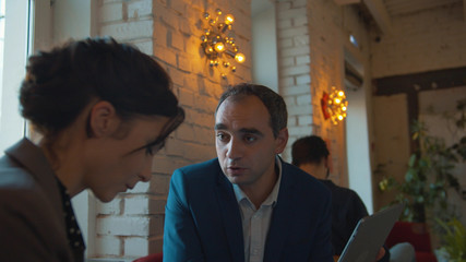 Businessman says something nervously to a colleague