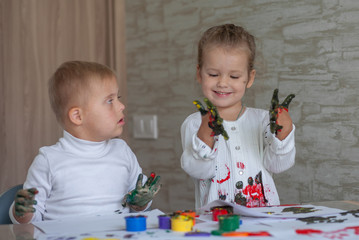 Little children paint with paints. The kids got their hands dirty in gouache. A cute girl and a boy...
