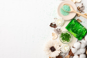 spa composition for body care on white wooden background with free copyspace mockup.  Skin care handmade product cosmetics for bath. Aloe vera craft soap and bath salt