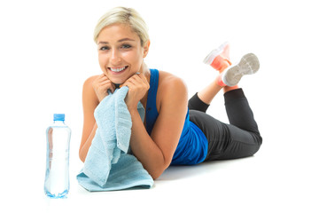 girl in a sports uniform lies on a yoga mat with a towel on a white background