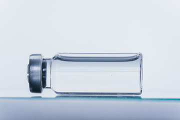 Glass medical ampoule vial for injection. Medicine is dry white drug penicillin powder or liquid with of aqueous solution in ampulla. Close up. Bottles ampule with aluminum cap on backgrounds gray.