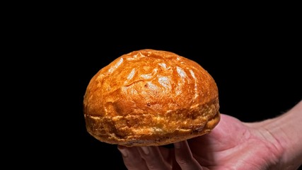 Air bun for craft burger is cooking on black background. Not made ideal. Looks real, loving hand made. Roll crispy bakery fresh bread.
