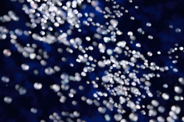 Abstract bokeh falling snow on a dark blue background winter motive
