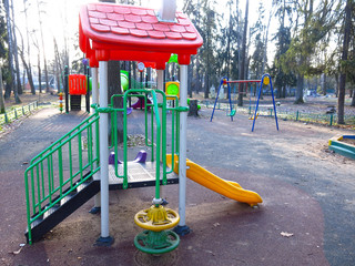 Playground with plastic slides, swings, sandbox, maze without children